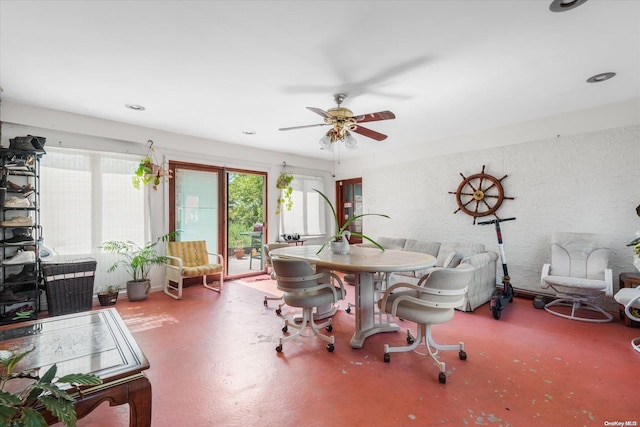 dining room featuring ceiling fan and concrete flooring