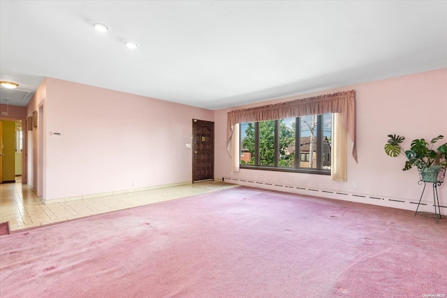 carpeted empty room with a baseboard heating unit