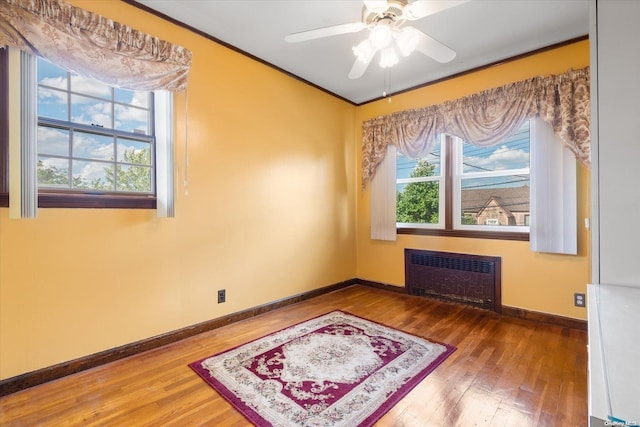 unfurnished room featuring radiator, ceiling fan, and wood-type flooring