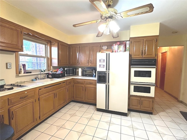 kitchen featuring ceiling fan, white appliances, sink, and light tile patterned floors