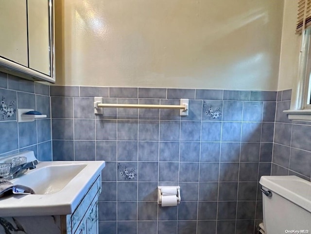 bathroom with sink, tile walls, and toilet