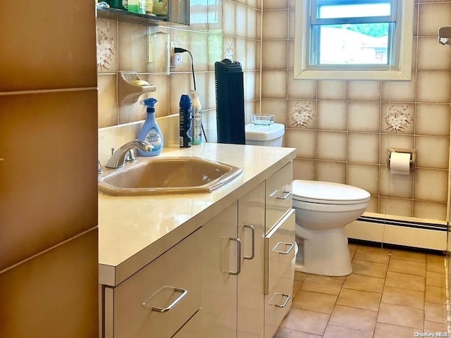 bathroom with vanity, a baseboard radiator, tile walls, tile patterned flooring, and toilet