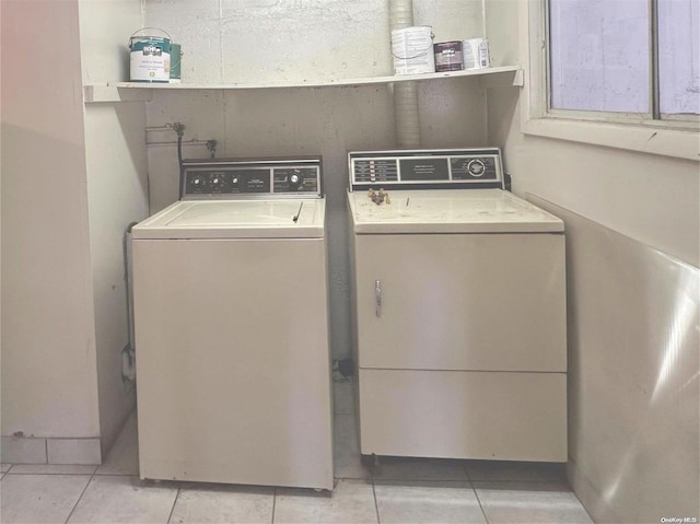 clothes washing area featuring separate washer and dryer and light tile patterned floors