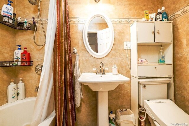 bathroom featuring shower / bathtub combination with curtain and toilet