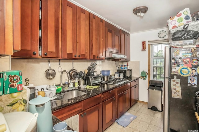 kitchen featuring dark stone counters, sink, range hood, tasteful backsplash, and stainless steel appliances