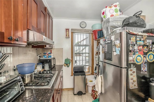 kitchen with ornamental molding, backsplash, stainless steel appliances, and dark stone counters