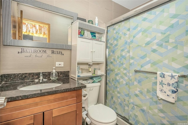 bathroom featuring walk in shower, vanity, and toilet