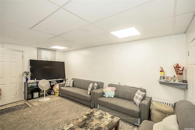 living room with a paneled ceiling and tile patterned floors