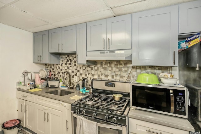 kitchen featuring a paneled ceiling, backsplash, sink, gray cabinets, and stainless steel appliances