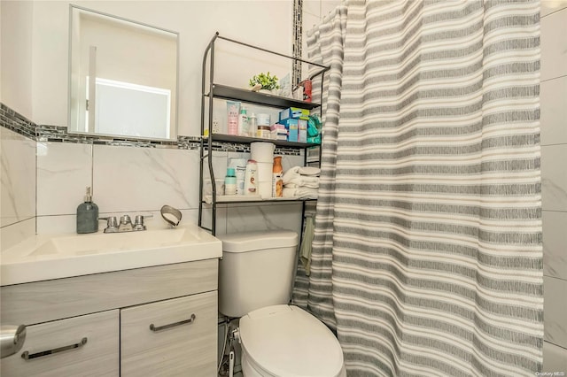 bathroom with vanity, tile walls, and toilet