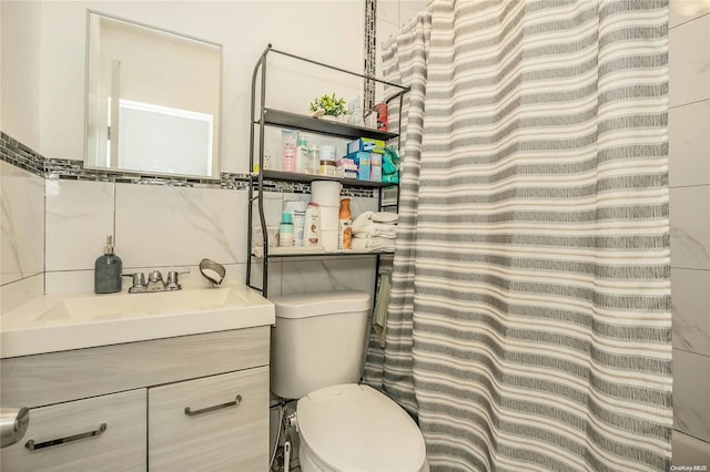 bathroom featuring vanity, toilet, and tile walls