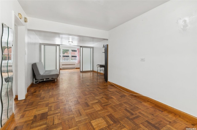 interior space with radiator heating unit and dark parquet floors