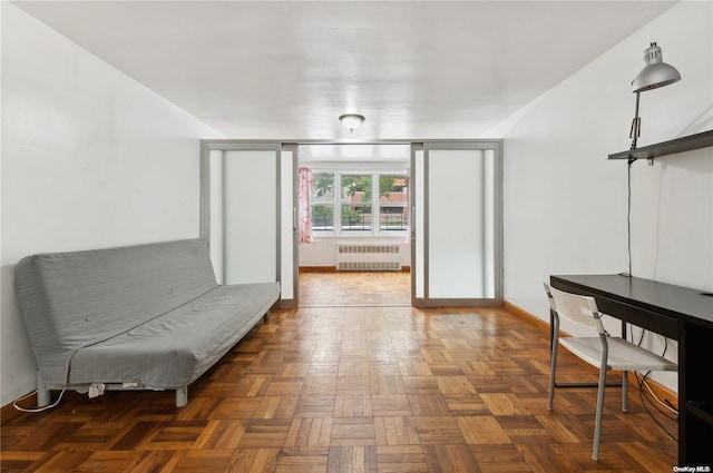 living area featuring dark parquet floors and radiator