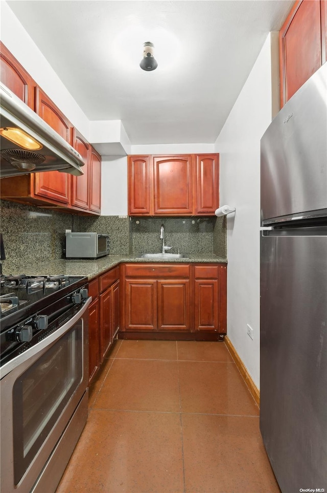 kitchen featuring tasteful backsplash, sink, stainless steel appliances, and dark tile patterned flooring