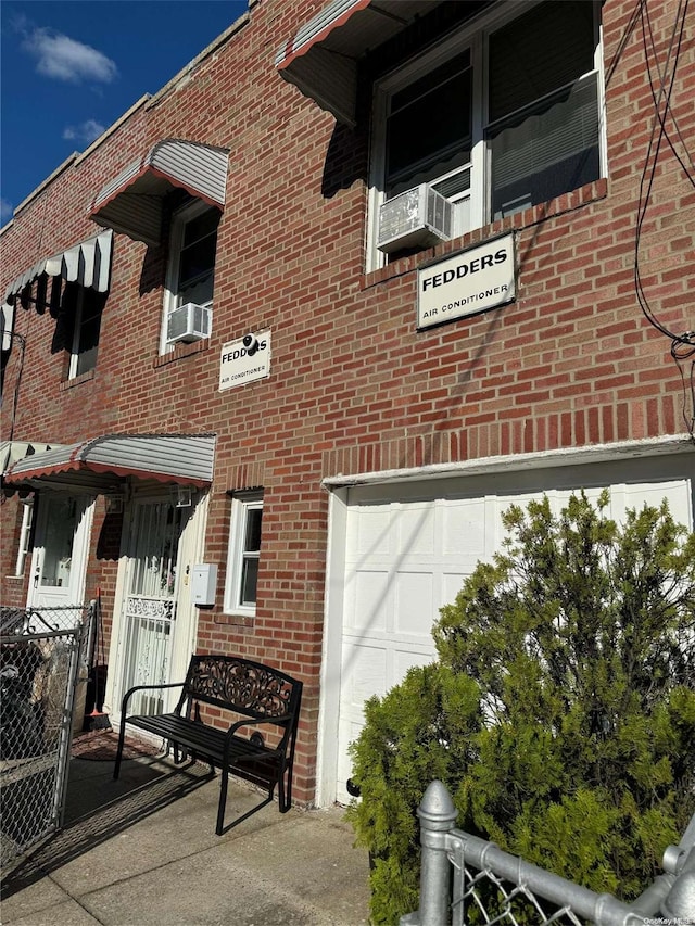 view of building exterior featuring a garage and cooling unit