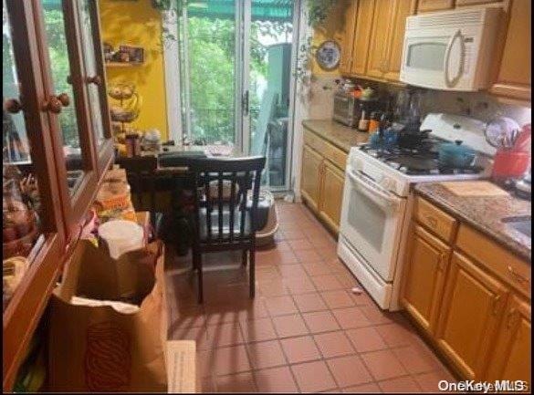 kitchen featuring light tile patterned floors and white appliances