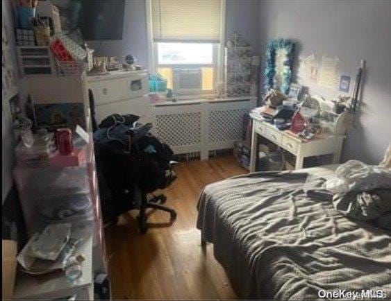 bedroom with hardwood / wood-style flooring and radiator