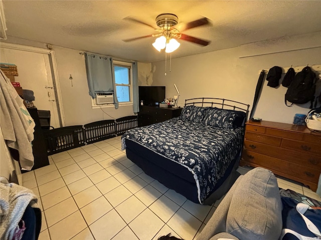 bedroom featuring cooling unit, ceiling fan, light tile patterned floors, and a textured ceiling