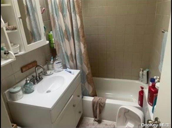 bathroom with vanity and shower / bath combo with shower curtain