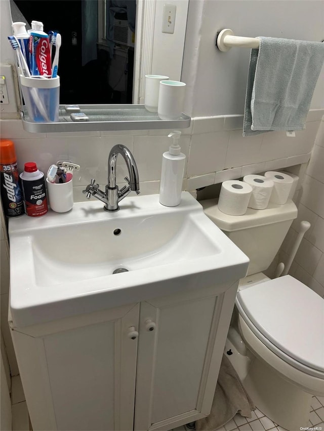 bathroom featuring vanity, tile patterned floors, toilet, tile walls, and tasteful backsplash