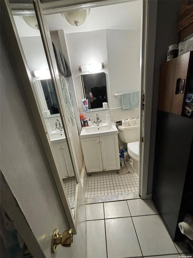 bathroom featuring tile patterned floors, vanity, and toilet