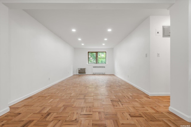 unfurnished room featuring radiator heating unit and light parquet flooring