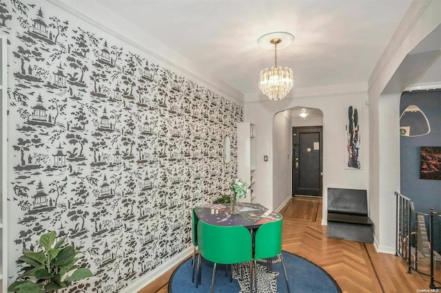 dining area featuring crown molding, parquet flooring, and an inviting chandelier