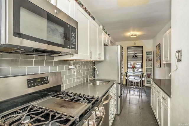 kitchen featuring decorative backsplash, white cabinetry, sink, and appliances with stainless steel finishes