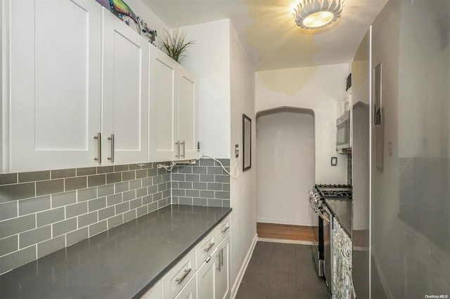 kitchen with white cabinets, backsplash, and stainless steel appliances