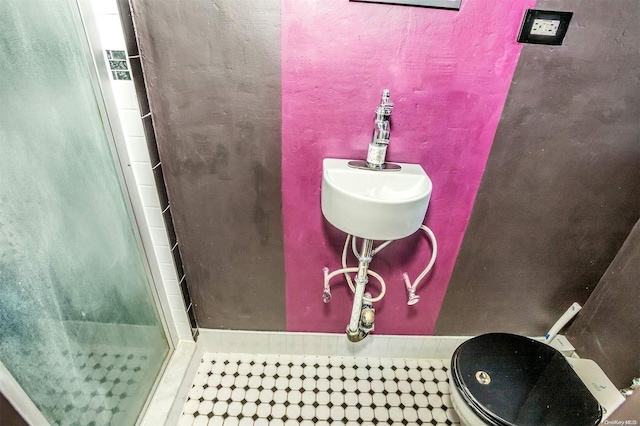 bathroom featuring tile patterned flooring, toilet, and an enclosed shower