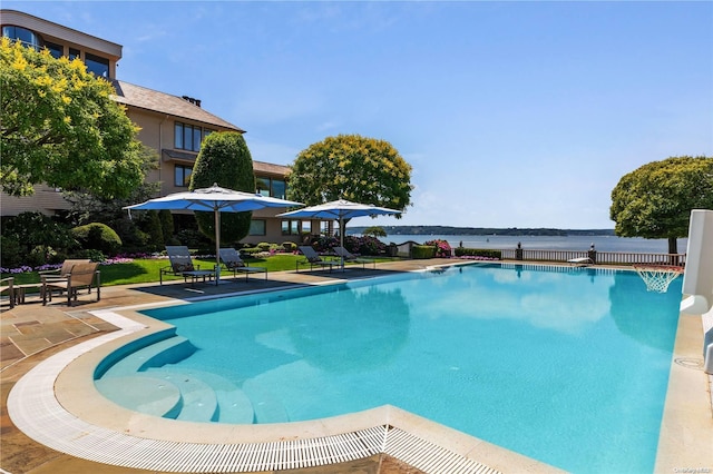 view of swimming pool featuring a patio area and a water view