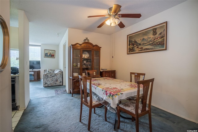 carpeted dining space with ceiling fan and a textured ceiling