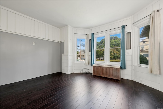 unfurnished room featuring radiator and dark wood-type flooring