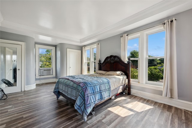 bedroom featuring multiple windows, cooling unit, and dark hardwood / wood-style floors