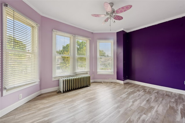 empty room with ceiling fan, crown molding, radiator, and light hardwood / wood-style flooring