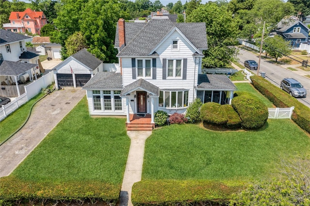 view of front of property featuring a front lawn, an outdoor structure, and a garage