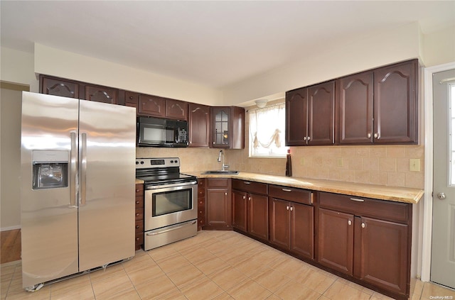 kitchen with backsplash, sink, dark brown cabinetry, and stainless steel appliances