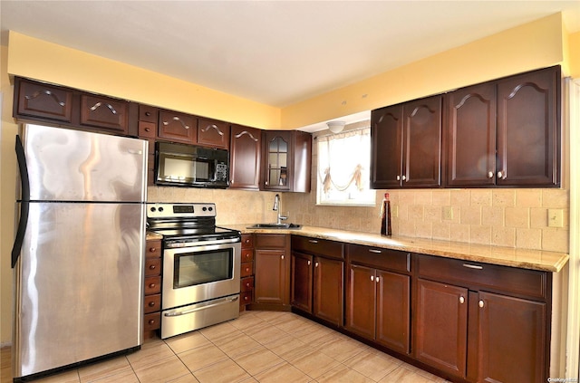 kitchen with sink, light stone countertops, tasteful backsplash, dark brown cabinetry, and stainless steel appliances