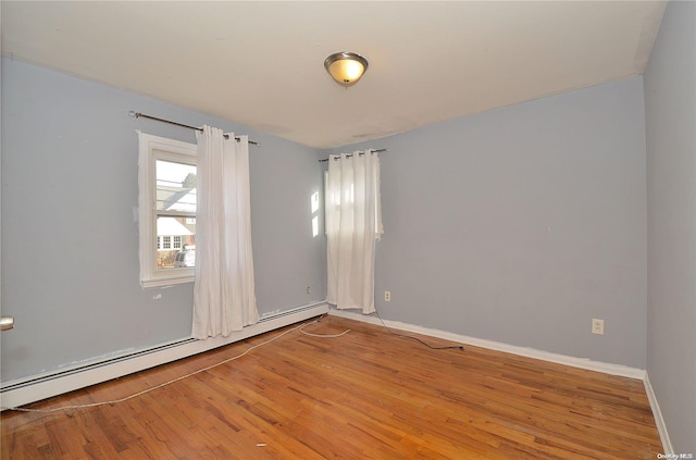 spare room featuring hardwood / wood-style flooring and baseboard heating