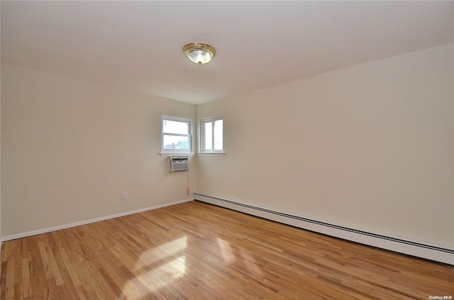 empty room with light hardwood / wood-style floors, a wall mounted AC, and a baseboard heating unit