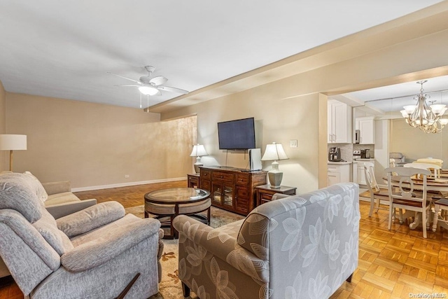 living room with ceiling fan with notable chandelier and light parquet flooring