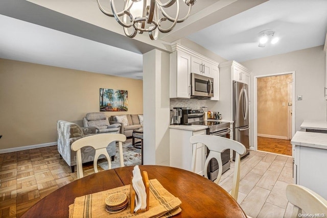 dining space featuring light parquet flooring and an inviting chandelier