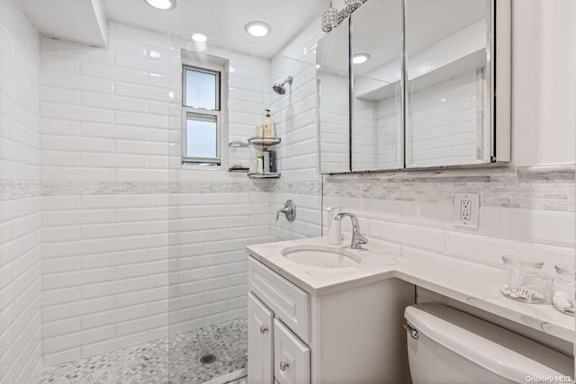 bathroom featuring an enclosed shower, vanity, toilet, and decorative backsplash