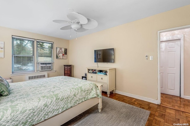 bedroom with ceiling fan, radiator heating unit, cooling unit, and dark parquet floors