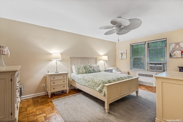 bedroom with ceiling fan, radiator heating unit, cooling unit, and parquet flooring