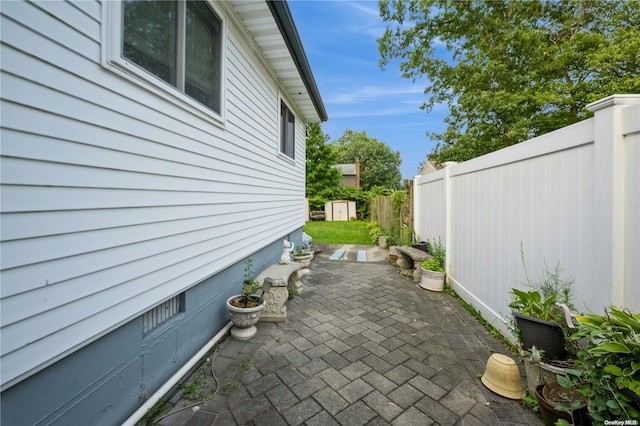 view of side of property featuring a storage shed and a patio area