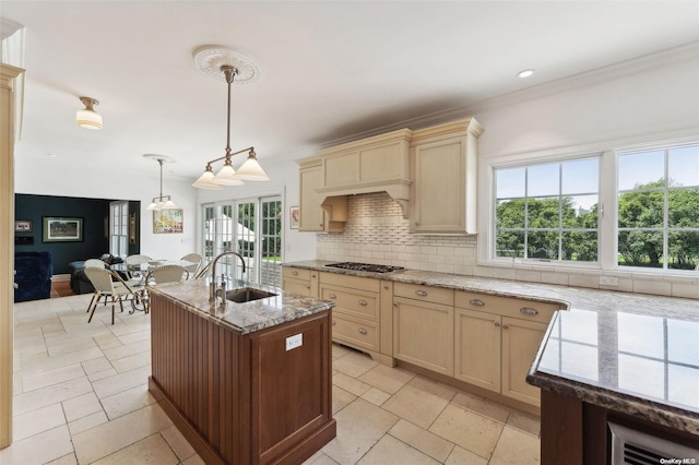 kitchen featuring decorative light fixtures, stainless steel gas cooktop, a wealth of natural light, and sink