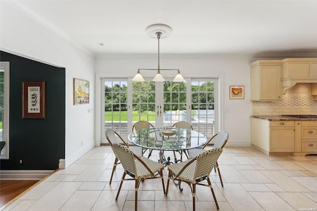 tiled dining room featuring french doors and crown molding