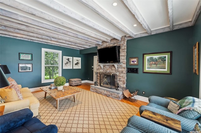 living room featuring beam ceiling, light hardwood / wood-style floors, and a fireplace