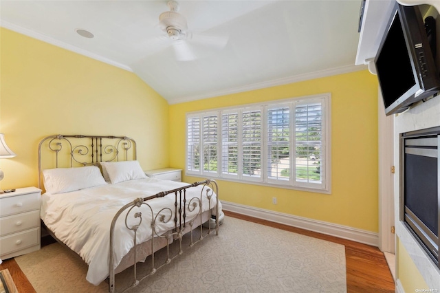 bedroom with ceiling fan, vaulted ceiling, crown molding, and light hardwood / wood-style flooring